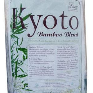 May include: A rolled-up white Twin-sized comforter in a clear plastic wrap. The label reads "Kyoto Bamboo Blend" with text and bamboo leaf illustrations. The dimensions are 72x90 inches.