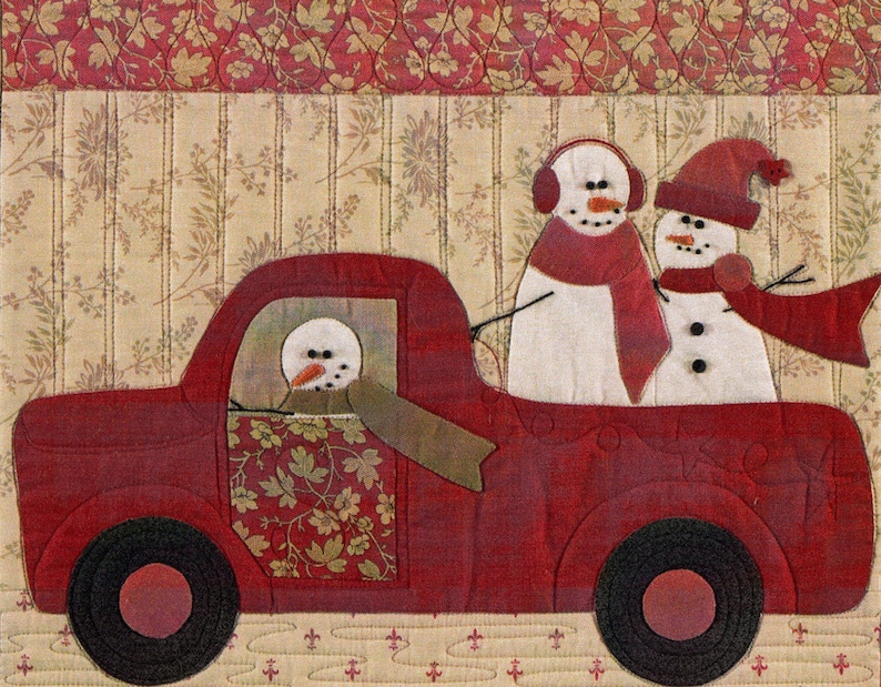 Puede incluir: Un cami&oacute;n de juguete rojo con tres mu&ntilde;ecos de nieve. El mu&ntilde;eco de nieve en el asiento del conductor lleva una bufanda verde. Los dos mu&ntilde;ecos de nieve en la parte de atr&aacute;s llevan bufandas rojas. El cami&oacute;n est&aacute; sobre un fondo estampado.
