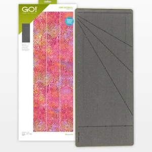 Könnte beinhalten: GO! Laminierte Schneidematte mit einem Blumenmuster und eine graue Schneidematte mit Linien und einer diagonalen Linie. Die Schneidematte ist 12x24 Zoll groß.