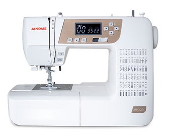 May include: White Janome sewing machine with a gold trim and a digital display. The machine has a variety of stitch options and a built-in needle threader.