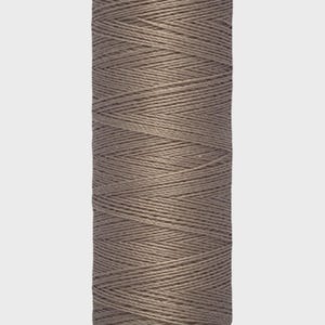May include: A spool of Gütermann thread in a muted taupe color. The label at the top reads "Gütermann" and the bottom label indicates 100 meters or 110 yards of thread. The thread is tightly wound around the spool.
