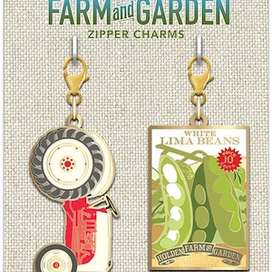 May include: Two gold-colored zipper charms featuring a red tractor and a vintage seed packet for white lima beans. The seed packet reads "White Lima Beans" and "Price 10 Cents". The charms are from Cathe Holden's Farm and Garden.