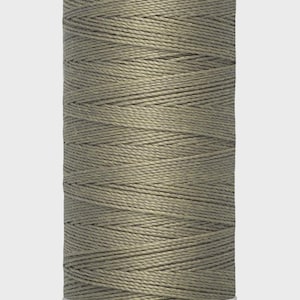 May include: A spool of Gütermann thread in a muted olive green colour. The spool is cylindrical with a white base and top, and the thread is tightly wound. The label reads "Gütermann" and "100 m - 110 yds/vgs".