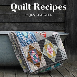 May include: A quilt with a patchwork design featuring various colors and patterns, including red, blue, yellow, and green. The quilt is folded and draped over a wooden surface. The text "Quilt Recipes by Jen Kingwell" is printed on a wooden background.