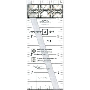Puede incluir: Una regla de acolchado rectangular transparente con patrones geométricos en blanco y negro en la parte superior. La regla presenta medidas, el texto "HRT SET A 3:1" y otro texto relacionado con el acolchado.