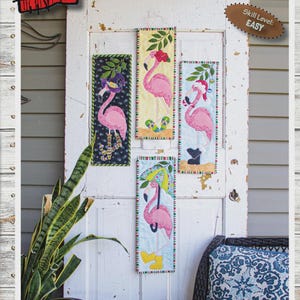 Könnte beinhalten: Dekorative Wandbehänge mit dem Text "LET'S FLAMINGO ALL YEAR" und vier Tafeln mit rosa Flamingo-Designs. Jede Tafel ist ca. 15 cm x 46 cm groß. Der Schwierigkeitsgrad ist einfach.