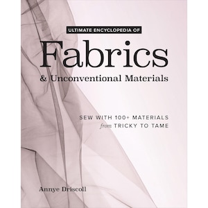 Könnte beinhalten: Buchcover mit dem Titel "Ultimate Encyclopedia of Fabrics & Unconventional Materials". Das Cover zeigt ein weiches, abstraktes Design in Rosa- und Grautönen. Der Text "Sew with 100+ Materials from Tricky to Tame" ist ebenfalls sichtbar.