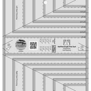 May include: A clear plastic quilting tool with gray and white markings and measurements in inches. The tool is labeled "Half Rectangle Trim Tool" and includes the Creative Grids logo. It features angled lines and text for trimming fabric.