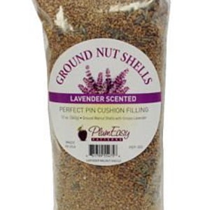 May include: A bag of ground nut shells for pin cushion filling. The bag is labeled "Ground Nut Shells Lavender Scented Perfect Pin Cushion Filling 11 oz Delic - Ground Walnut Shells with Ground Lavender Plant Envy Creations".