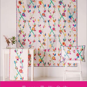 May include: A colourful quilt pattern with a whimsical Tuscan Garden theme. The quilt features a trellis design with green vines and colourful flowers. The pattern is shown in a quilt, table runner, and cushion.