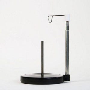 May include: A black metal thread stand with a silver metal rod and a hook. The stand has a round base and a tall, adjustable rod.