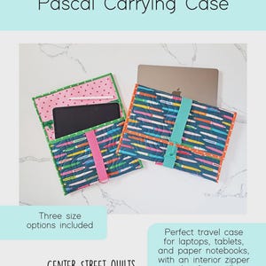 May include: Two quilted Pascal Carrying Cases featuring a dark blue fabric with a colorful pen pattern. One case is open, revealing a pink interior with small red hearts, a tablet, and a stylus. The other case is closed with a teal strap.