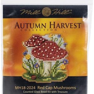 May include: A sealed plastic package featuring a counted glass bead kit. The kit showcases a cross-stitch design of red cap mushrooms with white spots, surrounded by flowers and greenery. The text reads "Autumn Harvest Collection" and "MH18-2024 Red Cap Mushrooms". Finished size is 2.5"w x 2.75"h.