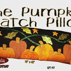 Pode incluir: Uma almofada retangular com fundo preto apresentando um design de aplique acolchoado de abóboras laranja e amarelas, folhas verdes e estrelas laranja. O texto diz The Pumpkin Patch Pillow, The Quilt Patch Pattern Company, 16" x 42" e QP145.