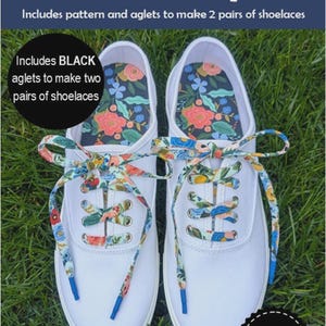 May include: A pair of white canvas sneakers featuring floral patterned shoelaces with blue aglets. The text reads Lace Up! Includes pattern and aglets to make 2 pairs of shoelaces. Includes BLACK aglets to make two pairs of shoelaces. Slice of Pi Quilts.