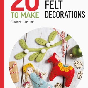 May include: A book cover with the title "All-New 20 Festive Felt Decorations to Make" by Corinne Lapierre. The cover features a white background with a circle in the center showing a variety of felt Christmas ornaments, including a red and yellow horse, a blue angel, and a green mistletoe sprig.