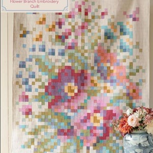 Peut inclure: Une courtepointe florale avec un motif pixélisé dans les tons de rose, de violet, de bleu et de jaune. La courtepointe présente un motif de broderie de branches de fleurs. Le texte "CHAMBRAY BASICS Flower Branch Embroidery Quilt" est dans le coin supérieur gauche.