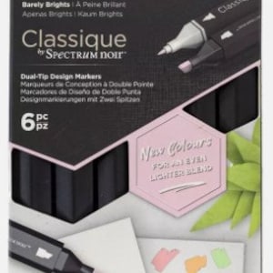 Może przedstawiać: Zestaw sześciu dwustronnych markerów do projektowania w czarnym opakowaniu. Markery są oznaczone "Classique by Spectrum Noir" i zawierają tekst "Barely Brights" oraz "New Colours for an even lighter blend".