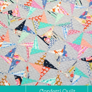 Può includere: Un motivo di trapunta a coriandoli colorato su sfondo grigio. La trapunta è realizzata con diversi tessuti con motivi e colori diversi, tra cui rosa, blu, verde e arancione. La trapunta è legata con un nastro e ha il testo "Confetti Quilt" e "A fantastic quilt for Fat 1/4 Bundles or for Scraps!" stampato su di essa.