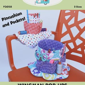 May include: Two fabric organizers labeled Pincushion and Pockets and Wingman Pop-ups. One organizer features white fabric with colorful polka dots and red grid patterns. The other features purple and blue fabric with sewing machine graphics.