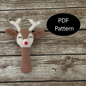 May include: Crochet reindeer rattle toy with brown and white yarn, red nose, and black eyes. PDF Pattern.