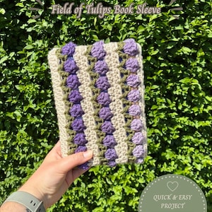 May include: A rectangular crochet book sleeve featuring a repeating pattern of purple tulip-shaped clusters separated by olive green stems on a beige background. The text PDF Pattern Field of Tulips Book Sleeve is visible at the top.