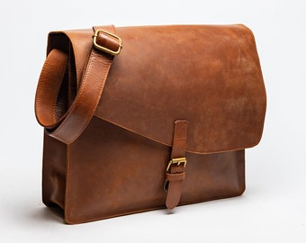 May include: A brown leather messenger bag with a long adjustable strap and a brass buckle closure.