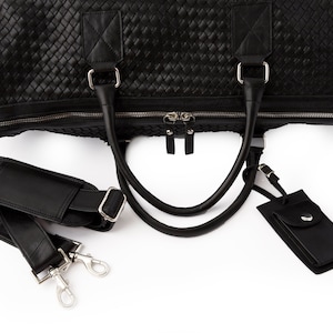 May include: Black leather woven duffel bag with a detachable shoulder strap and a small black leather tag.