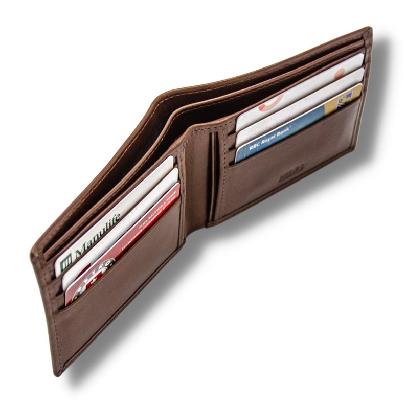 May include: A brown leather wallet with multiple card slots and a billfold. The wallet is open and shows several cards inserted in the slots, including a Manulife card and an RBC Royal Bank card.