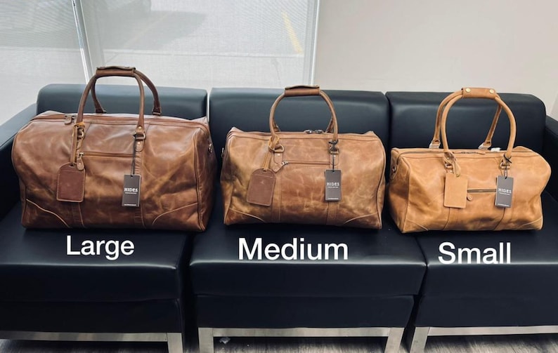 K&ouml;nnte beinhalten: Drei braune Leder-Reisetaschen in verschiedenen Gr&ouml;&szlig;en. Die Taschen sind mit "Gro&szlig;", "Mittel" und "Klein" beschriftet.