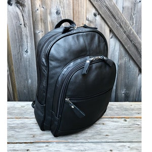 Pu&ograve; includere: Uno zaino in pelle nera con pi&ugrave; scomparti con cerniera. Lo zaino ha un design elegante e moderno.