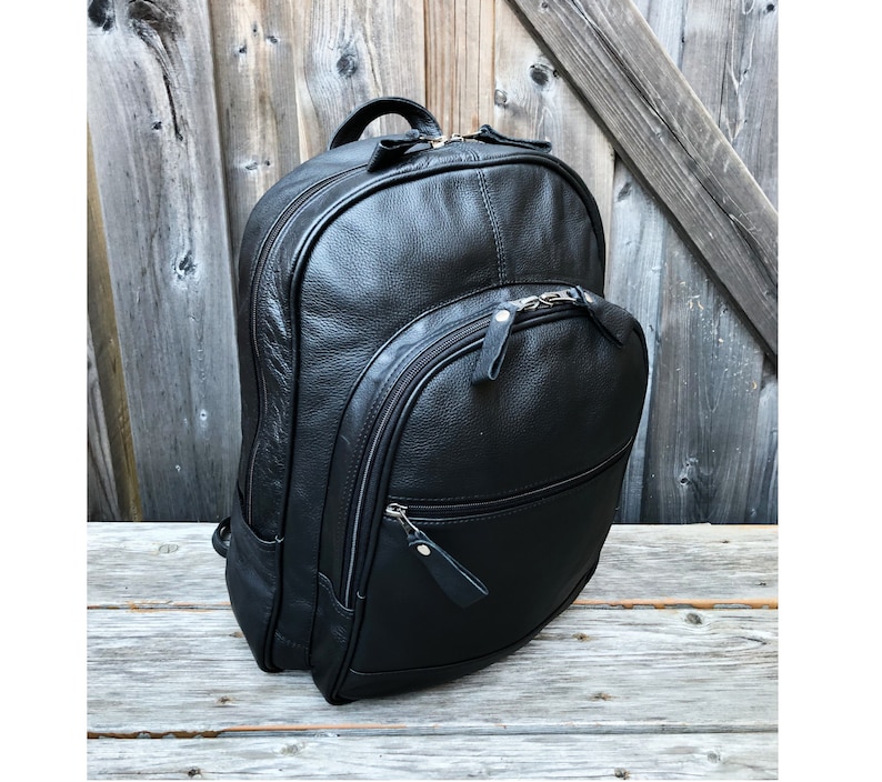 Pu&ograve; includere: Uno zaino in pelle nera con pi&ugrave; scomparti con cerniera. Lo zaino ha un design elegante e moderno.