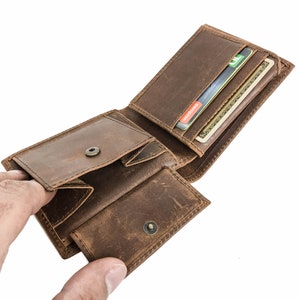 Pu&ograve; includere: Un portafoglio in pelle marrone con pi&ugrave; slot per carte e un portafoglio per banconote. Il portafoglio &egrave; aperto e contiene diverse carte.