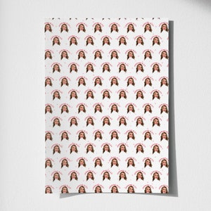 Op de afbeelding: Wit inpakpapier met een herhalend patroon van een vrouwen gezicht en de tekst "Manic Pixie Dream Girl".
