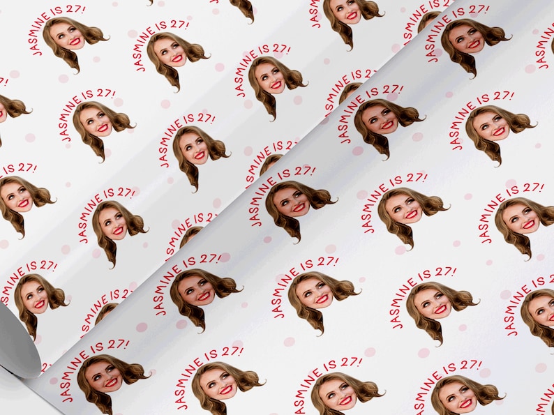Op de afbeelding: Wit inpakpapier met een herhalend patroon van een vrouwen gezicht met de tekst "JASMINE IS 27!" in rood. De achtergrond heeft kleine roze stippen.
