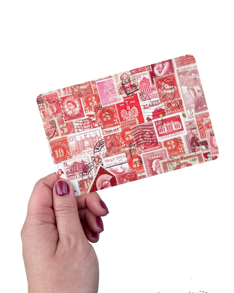 May include: A rectangular card with a collage of vintage postage stamps in red and pink hues. The stamps showcase diverse designs, including portraits and buildings. The card is held by a hand with painted nails.