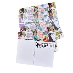 K&ouml;nnte beinhalten: Ein Stapel rechteckiger Postkarten mit einer Collage aus verschiedenen Briefmarken, die Katzen und Tiger zeigen. Die oberste Postkarte ist auf der R&uuml;ckseite wei&szlig; und mit dem Wort Postcard in schwarzer Schrift sowie einem Briefmarkenfeld.