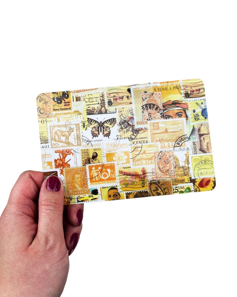 May include: A rectangular postcard with a yellow hue, covered in a collage of vintage postage stamps. The stamps display diverse designs, including butterflies, portraits, and international landmarks. The postcard is held by a hand.