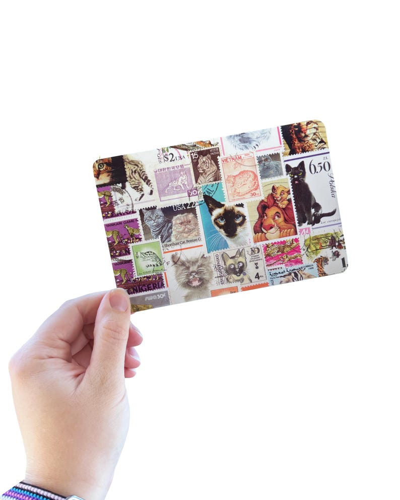 K&ouml;nnte beinhalten: Eine rechteckige Karte mit einer Collage aus verschiedenen Briefmarken, die jeweils unterschiedliche Katzenillustrationen zeigen, darunter Hausrassen und Zeichentrickfiguren, mit sichtbarem Text wie USA 22, 6.50 und internationalen Markierungen.