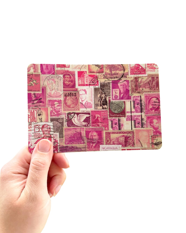 May include: A rectangular pink and white collage of vintage postage stamps. The stamps feature portraits, buildings, and text from various countries. The collage is held in a hand against a white background.