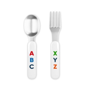 May include: A set of two stainless steel children's utensils with white handles. The spoon has a red "A", blue "B", and a navy "C" on the handle. The fork has a green "X", a blue "Y", and an orange "Z" on the handle.