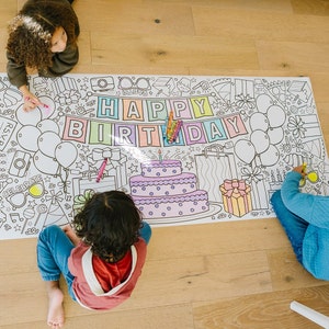 Happy Birthday decor banner being colored at kids birthday party.