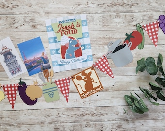 May include: A festive banner with a French theme, featuring cutouts of food, kitchen utensils, and iconic landmarks. The banner includes a birthday card that says "Jonah is Four" and "Happy Birthday". The banner is decorated with red and white checkered flags.