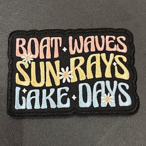 May include: Embroidered patch with the words "BOAT. WAVES SUN. RAYS LAKE. DAYS" in pastel colors. The patch has a black border and small daisy accents. The patch is rectangular.