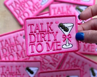 May include: Pink iron-on patches with the text "Talk Dirty To Me" and a martini glass with an olive.