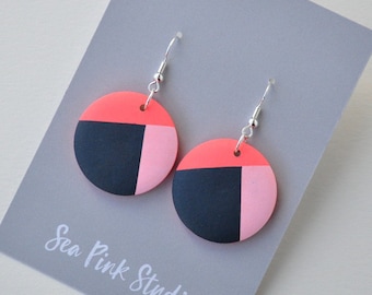 Neon pink and navy wooden earrings hand painted in a geometric design