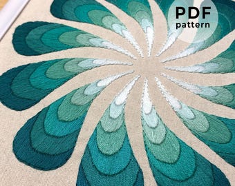 May include: A teal and green embroidery pattern on a beige fabric background. The pattern is a circular design with 12 petals that are made up of concentric circles. The pattern is titled "PDF pattern".