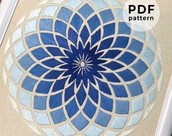 May include: A blue and white geometric mandala embroidery pattern, with a gradient of blue shades. The pattern is circular and has a flower-like design in the center. The text "PDF pattern" is visible in the upper right corner of the image.