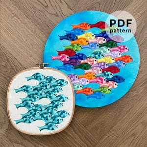 May include: Two embroidery hoops with colorful fish designs. The top hoop shows a school of rainbow fish swimming in a blue circle. The bottom hoop shows a school of teal fish swimming in a white circle. The text "PDF pattern" is in the top right corner of the image.
