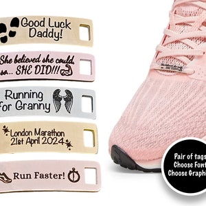 May include: A collection of personalized shoe tags in various colors, with engraved text and graphics. The tags include phrases like "Good Luck Daddy!" and "Run Faster!" A pink running shoe is also shown.